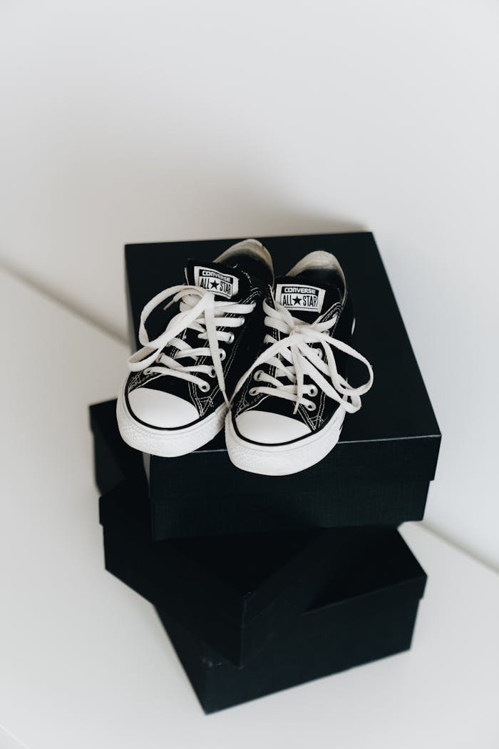 bedroom-bliss Black sneakers on a stack of boxes, offering a sleek and modern style.